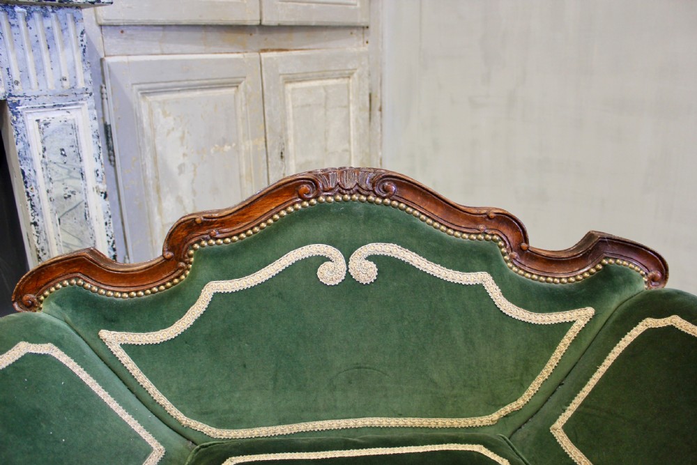 A pair of mid-19th century French Rococo revival armchairs upholstered in forest green velvet with contrasting cream braided trim and carved timber frames. View III