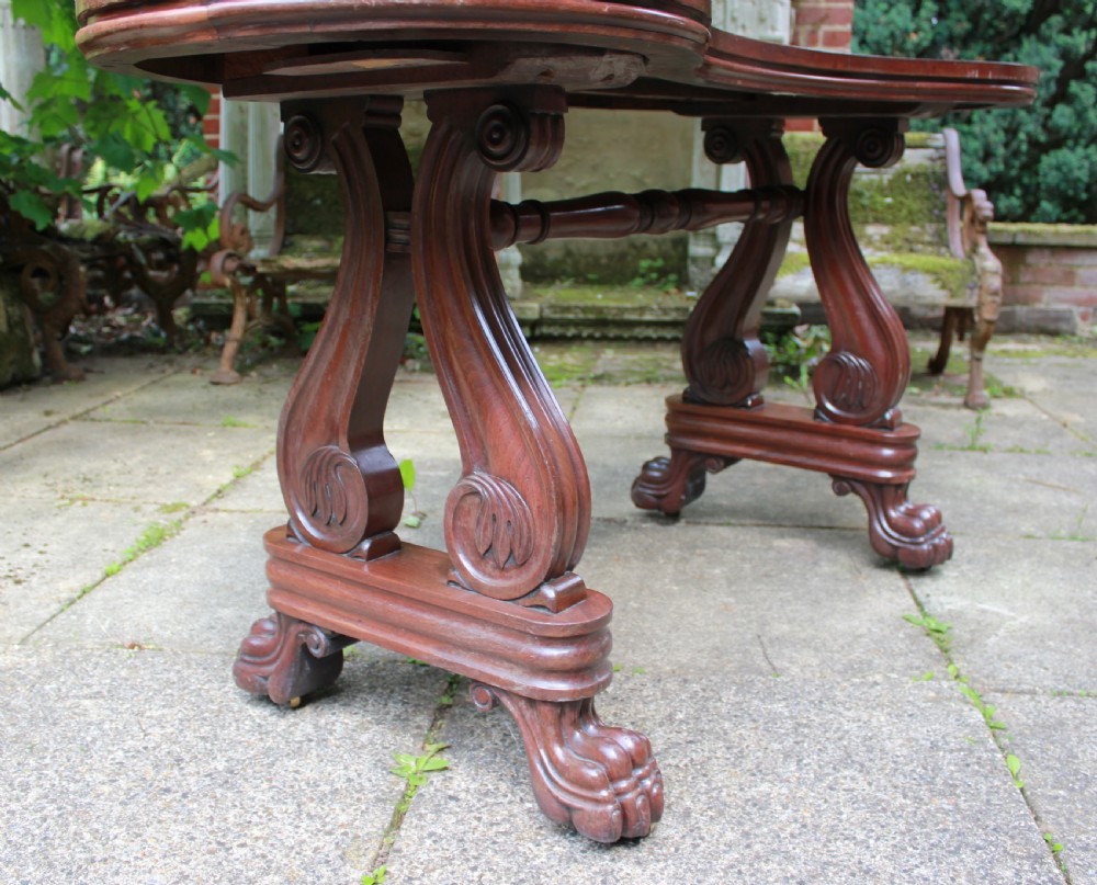An early 19th-century mahogany kidney-shaped writing table with carved scroll trestle legs, a turned stretcher, and carved claw feet. View IV