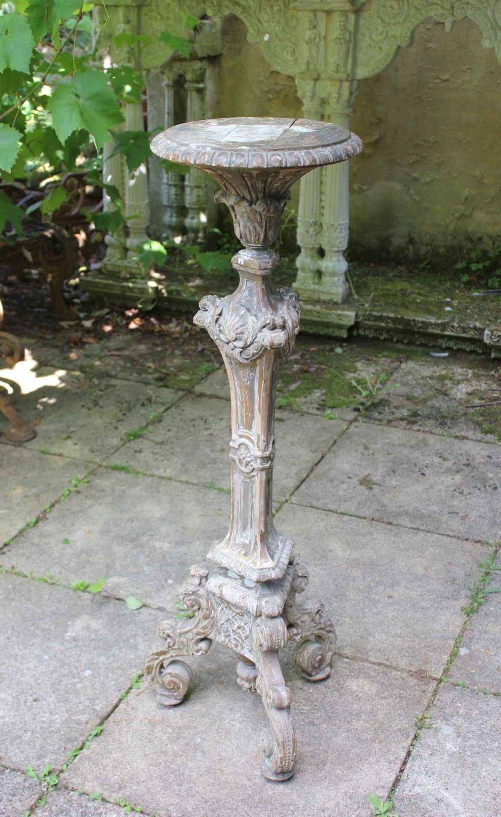 A tall, 19th-century carved wood torchere featuring a distressed weathered grey finish, detailed acanthus leaf carvings, and a tripod scroll base. View II