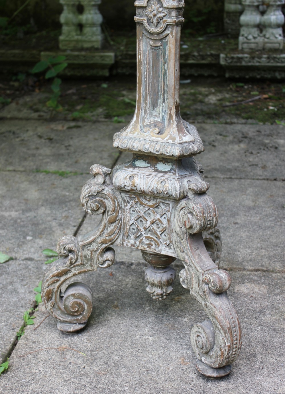 A tall, 19th-century carved wood torchere featuring a distressed weathered grey finish, detailed acanthus leaf carvings, and a tripod scroll base. View III