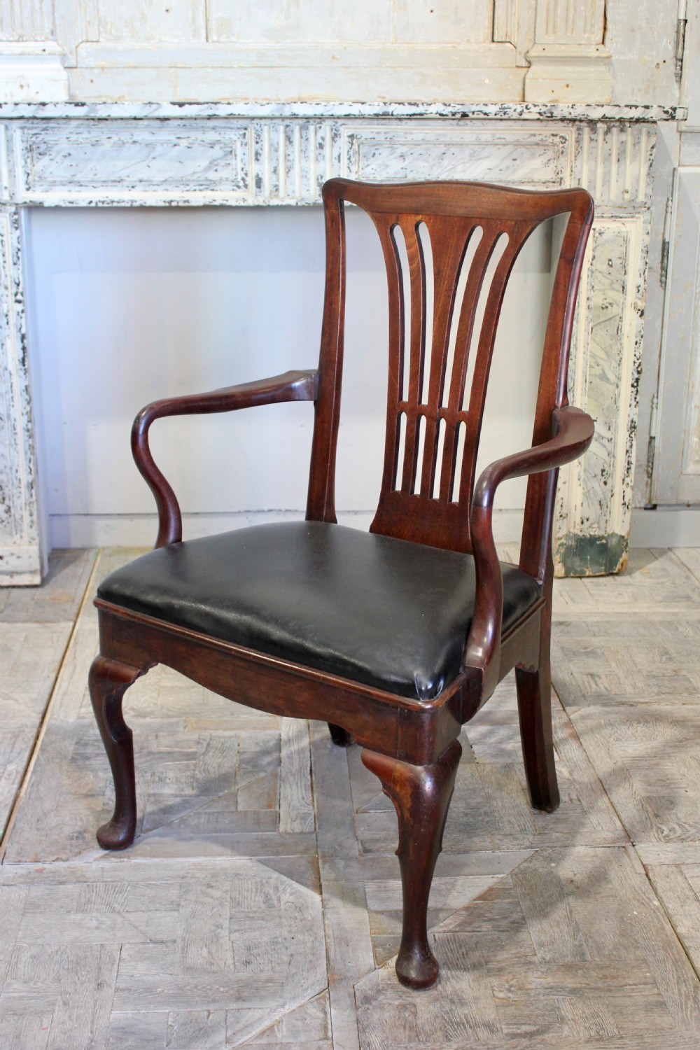 An 18th-century Georgian mahogany armchair featuring a carved pierced splat back, outcurved armrests, cabriole front legs with pad feet, and a dark leather drop-in seat. View III