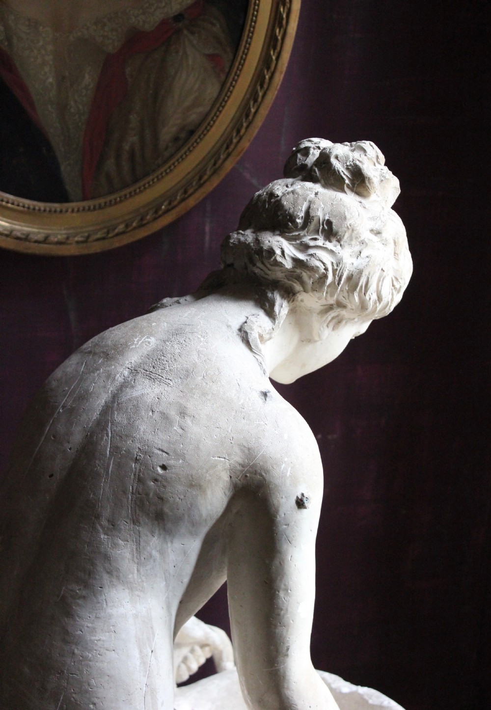 A full-length off-white plaster statue depicting a classical draped female figure standing beside a pedestal basin. View III