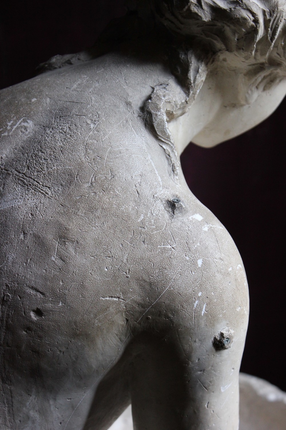 A full-length off-white plaster statue depicting a classical draped female figure standing beside a pedestal basin. View X