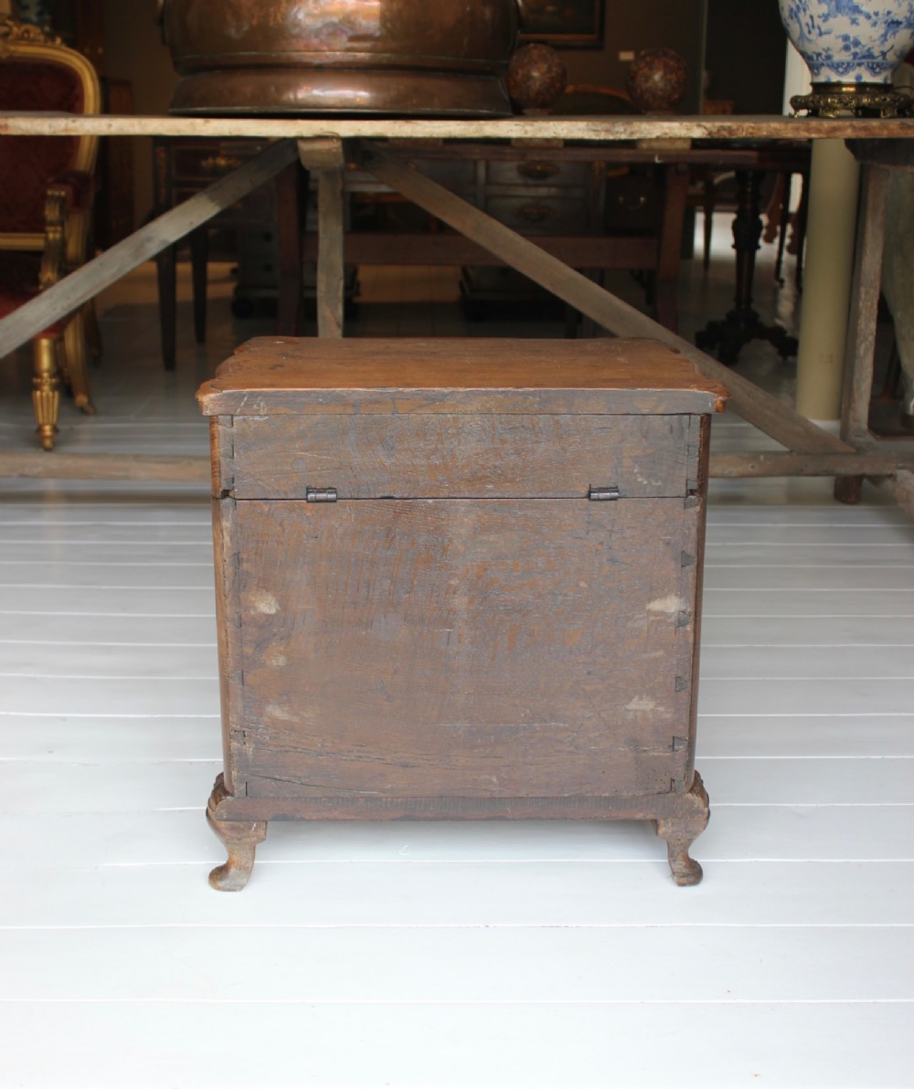An 18th-century wooden close stool featuring false drawer fronts, brass drop handles, side carrying handles, and short turned feet. View V