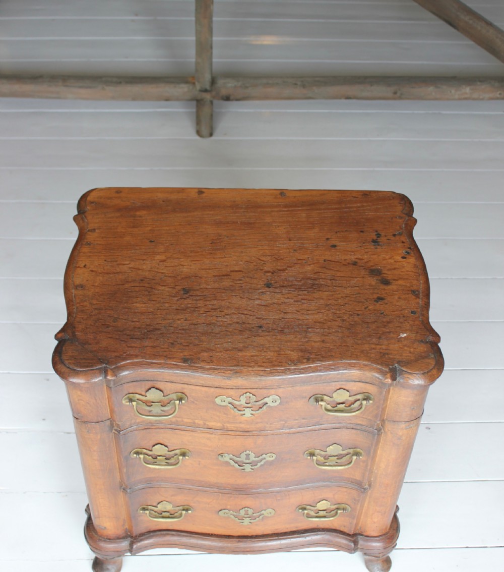 An 18th-century wooden close stool featuring false drawer fronts, brass drop handles, side carrying handles, and short turned feet. View VII