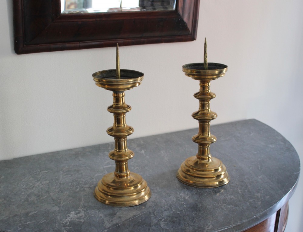 A pair of 16th-century brass pricket candlesticks featuring turned knopped stems and stepped circular bases. View III