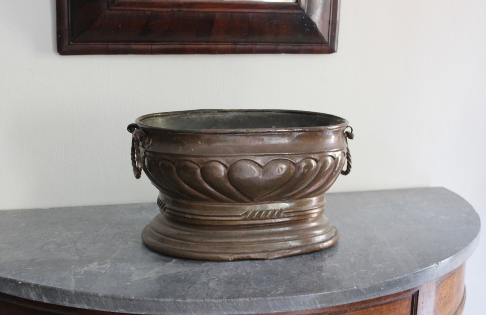 An eighteenth-century oval copper wine cooler with repousse gadrooned detailing, twisted rope side handles, and a stepped base. View VI