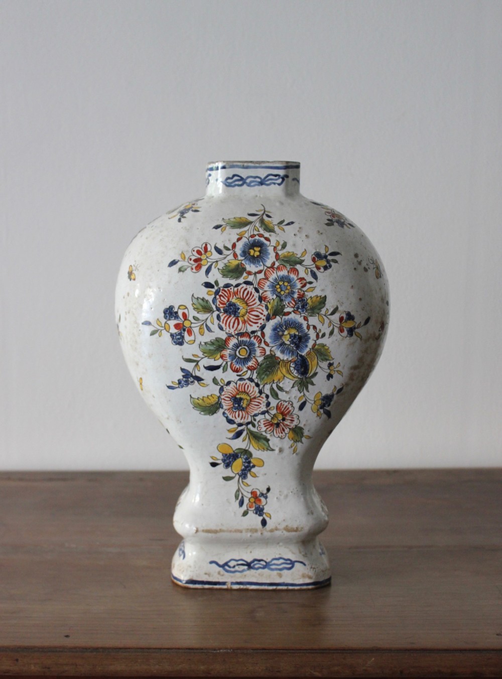 An eighteenth-century off-white tin-glazed ceramic vase decorated with hand-painted polychrome floral motifs across the front. View III