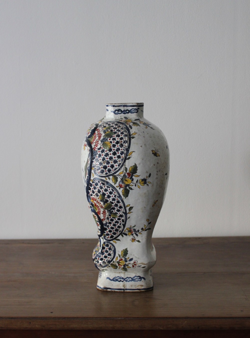 An eighteenth-century off-white tin-glazed ceramic vase decorated with hand-painted polychrome floral motifs across the front. View VI