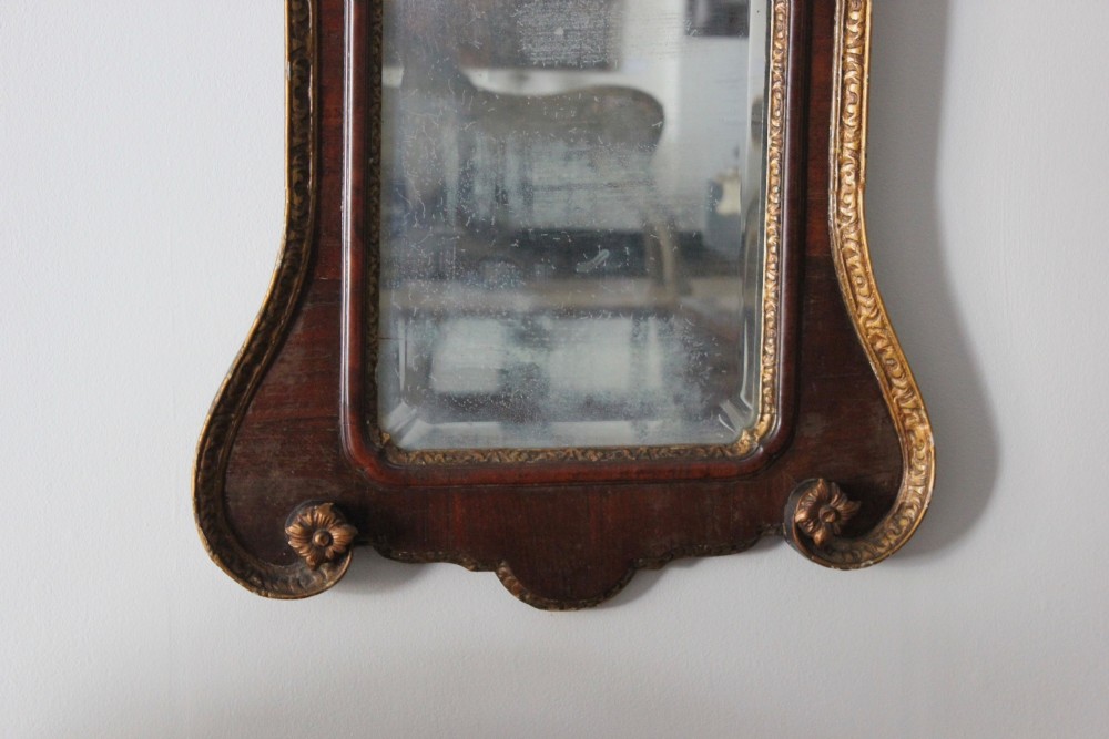 A mid-18th century Georgian mahogany wall mirror featuring a scrolled crested top with a gilded finial and carved slip moulding. View III