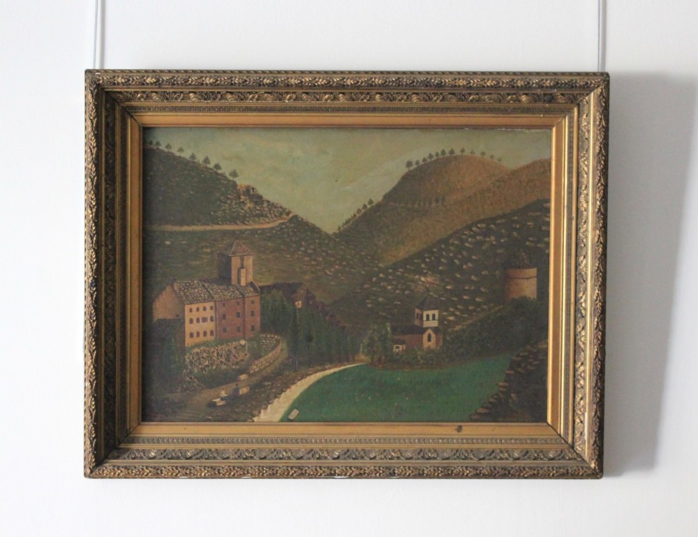 A 19th-century primitive oil painting depicting rolling hills, village buildings, and a winding path, housed in an ornate gilded frame. View III