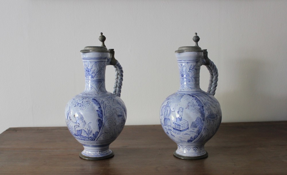 A matched pair of tin-glazed blue and white earthenware ewers featuring pewter hinged lids and twisted handles. View III