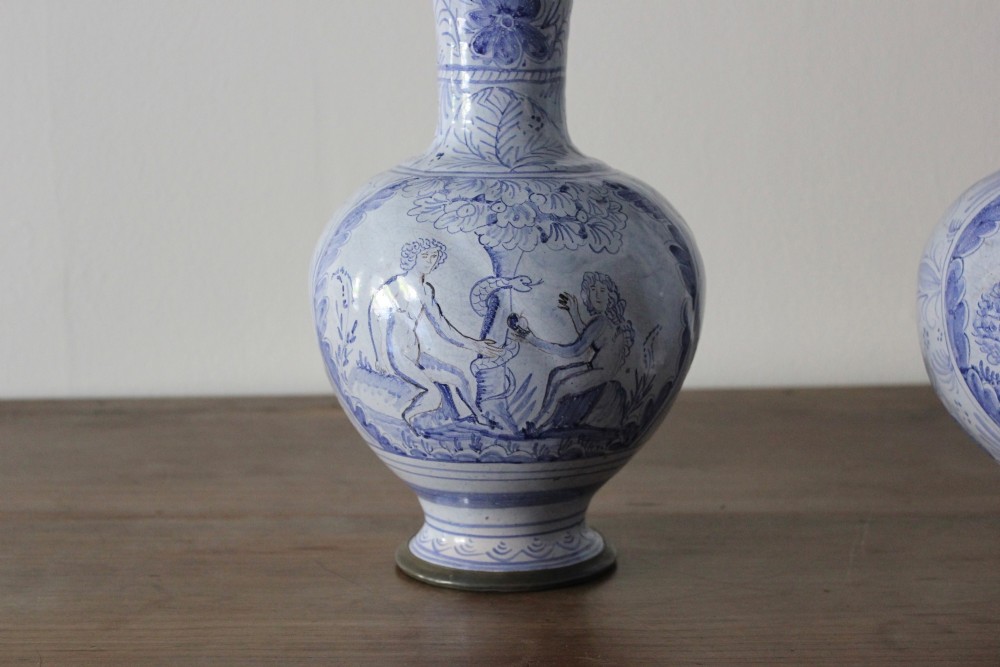 A matched pair of tin-glazed blue and white earthenware ewers featuring pewter hinged lids and twisted handles. View VI