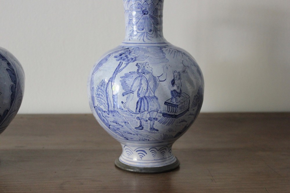 A matched pair of tin-glazed blue and white earthenware ewers featuring pewter hinged lids and twisted handles. View VII
