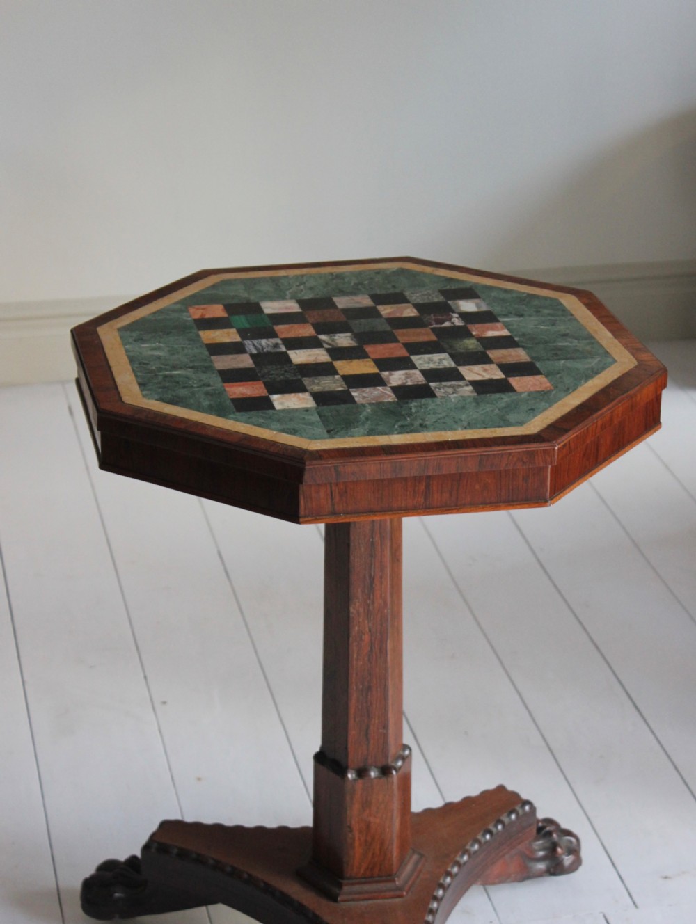 An early 19th-century Regency octagonal side table featuring an inlaid specimen marble chess top, an octagonal stem, and a triform base with carved claw feet. View II