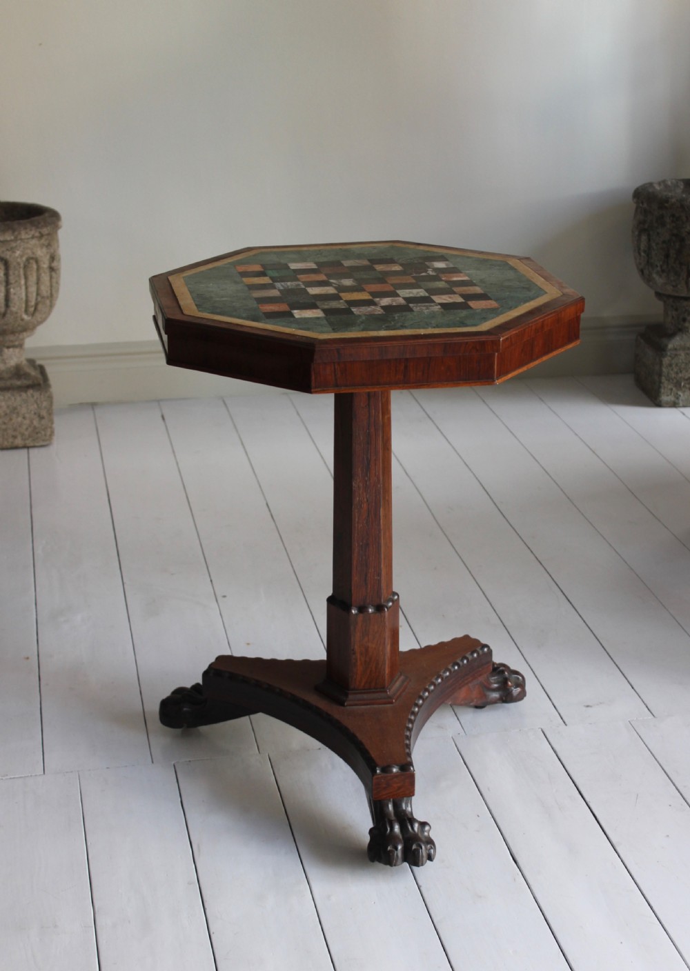 An early 19th-century Regency octagonal side table featuring an inlaid specimen marble chess top, an octagonal stem, and a triform base with carved claw feet. View III