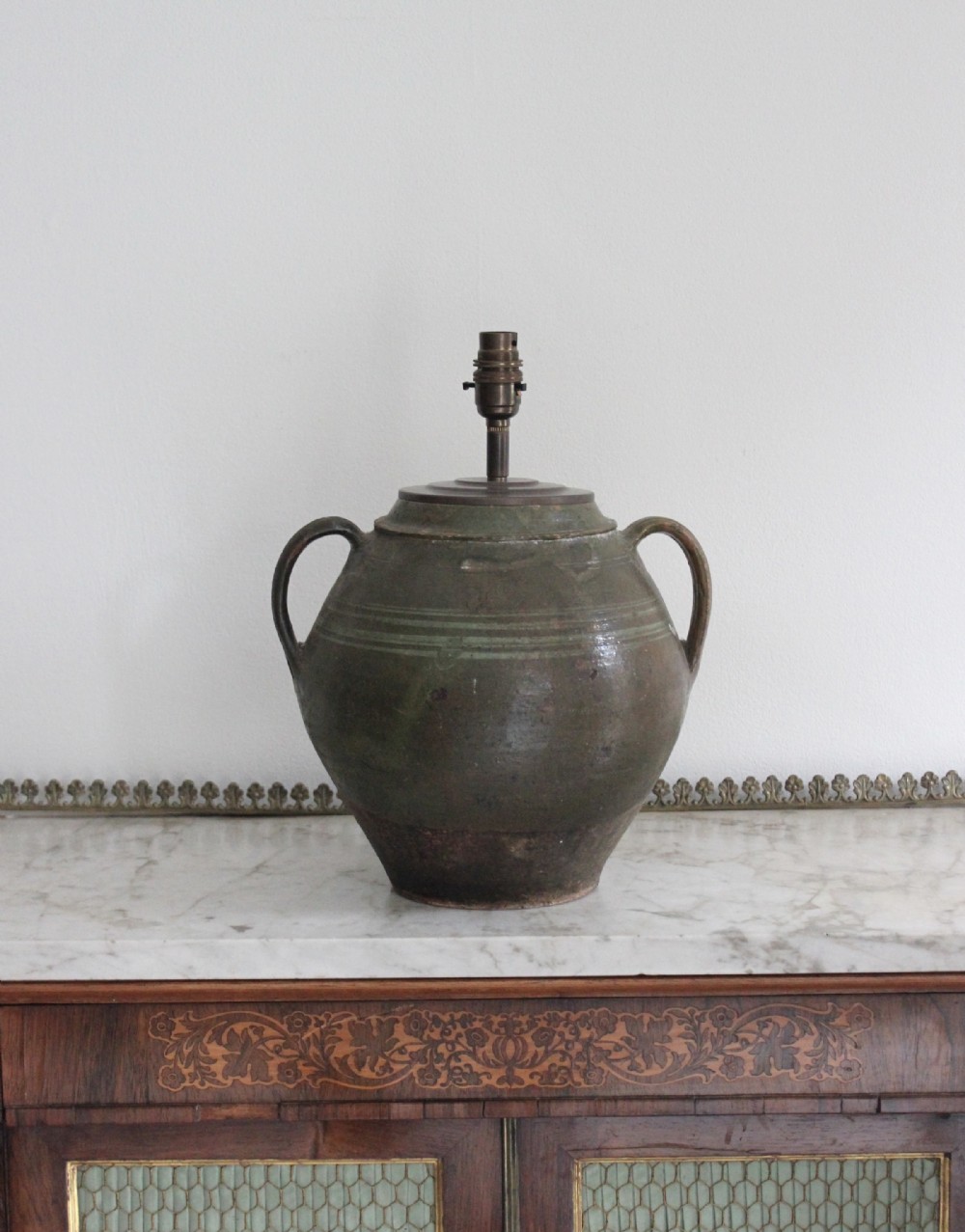 A green glazed earthenware jar featuring twin loop handles and incised line detailing, re-purposed as a table lamp base.