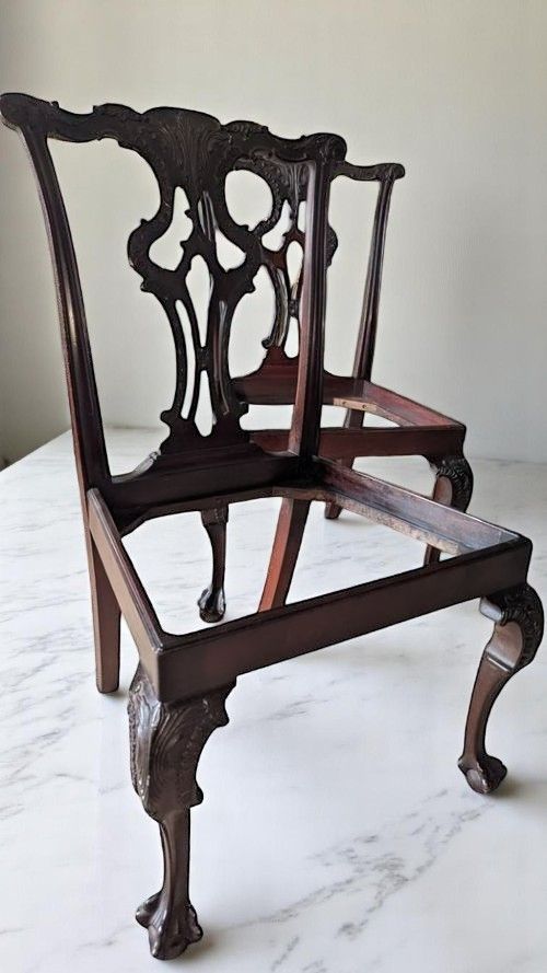 fig 1. A set of four dark mahogany Chippendale style dining chairs featuring carved pierced back splats, mustard velvet seats, and cabriole legs with ball and claw feet.