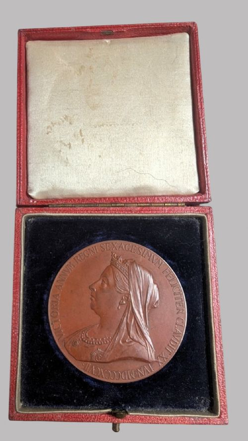 An official Victorian bronze commemorative medallion featuring a raised profile portrait of Queen Victoria, displayed inside its original fitted red presentation case lined with velvet. View II