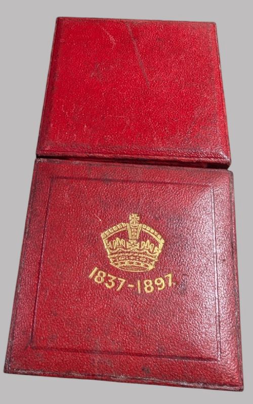 An official Victorian bronze commemorative medallion featuring a raised profile portrait of Queen Victoria, displayed inside its original fitted red presentation case lined with velvet. View V