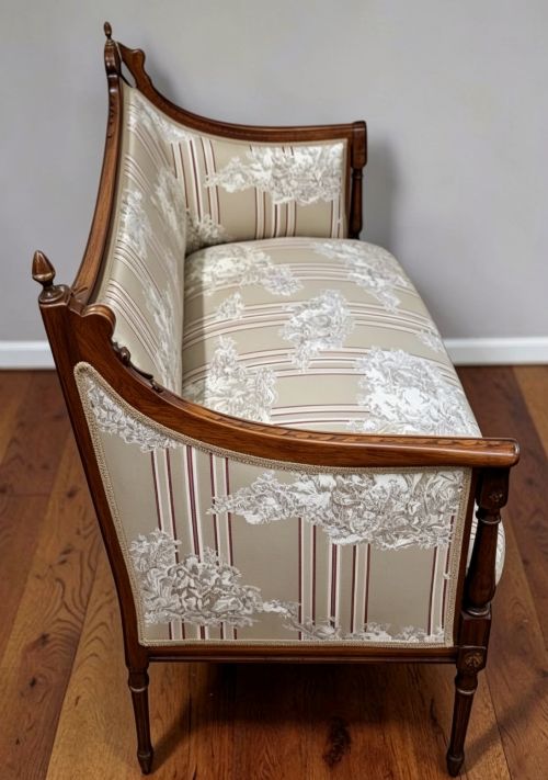 fig 2. An Edwardian walnut drawing room sofa with a curved backrest, turned finials, slender turned legs, and beige striped floral upholstery.