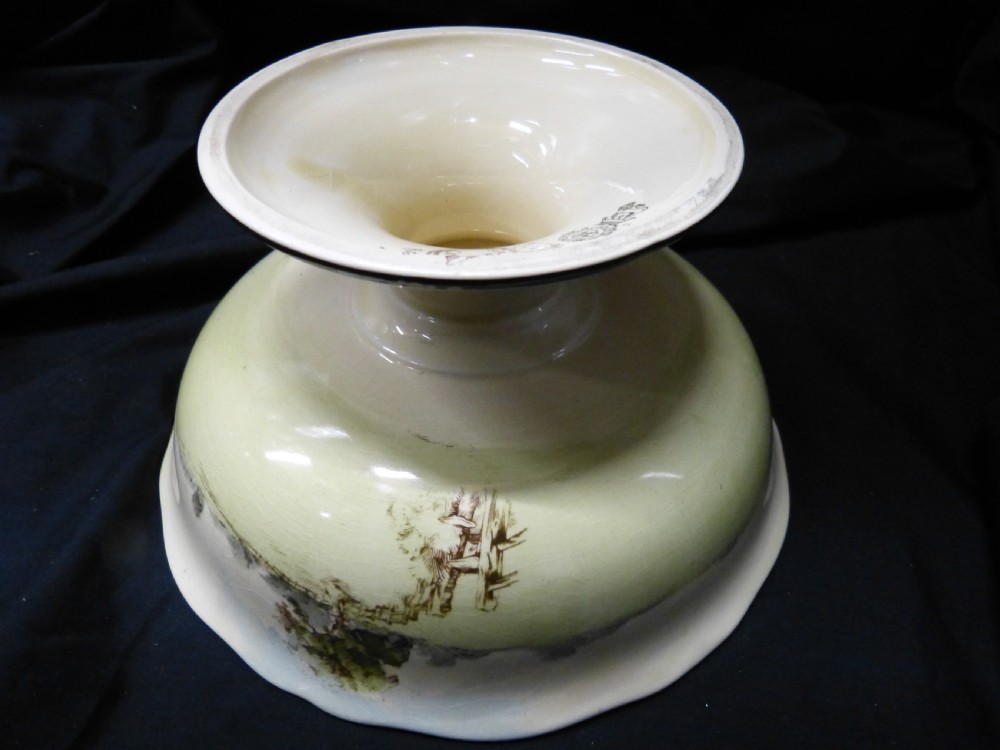A footed ceramic bowl with a scalloped rim, featuring a printed pictorial scene of figures in a rural landscape on the interior surface. View III