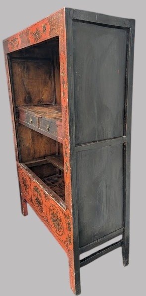 A 19th-century red lacquered Chinese open cabinet featuring hand-painted floral motifs on the outer frame and a central shelf with two small drawers. View II
