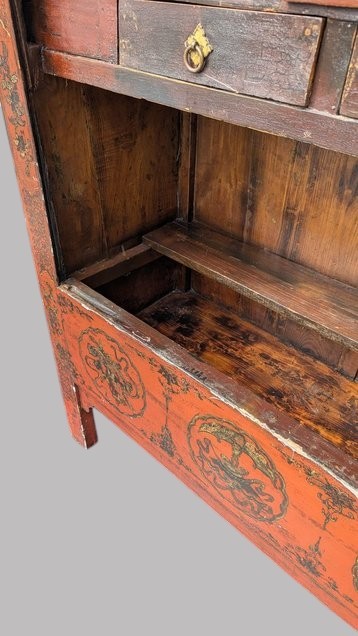 A 19th-century red lacquered Chinese open cabinet featuring hand-painted floral motifs on the outer frame and a central shelf with two small drawers. View III