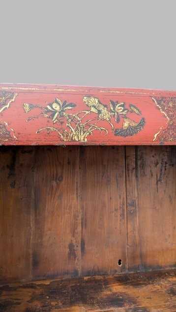 A 19th-century red lacquered Chinese open cabinet featuring hand-painted floral motifs on the outer frame and a central shelf with two small drawers. View V
