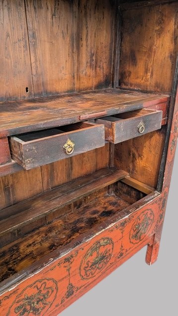 A 19th-century red lacquered Chinese open cabinet featuring hand-painted floral motifs on the outer frame and a central shelf with two small drawers. View VI