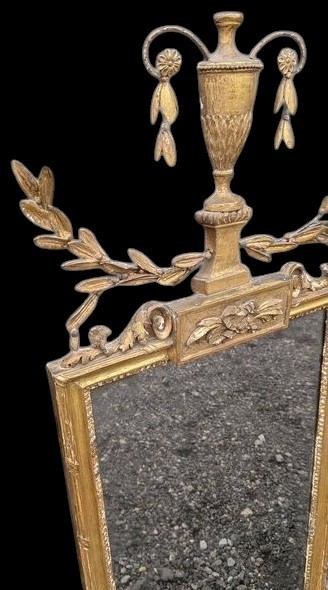 A late 19th-century rectangular Neoclassical giltwood wall mirror featuring an urn cresting and laurel branch swags. View II
