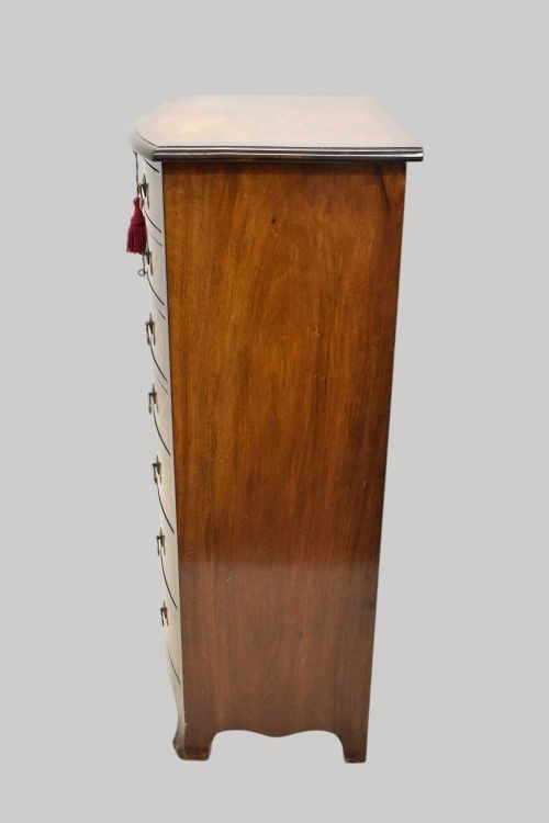 A tall Georgian style bowfront chest of drawers crafted in figured burr walnut with brass drop handles. View V