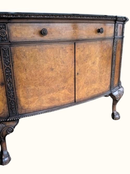 A semicircular burr walnut demi-lune sideboard featuring carved cabriole legs with ball-and-claw feet and decorative foliage carvings on the upright pilasters. View III