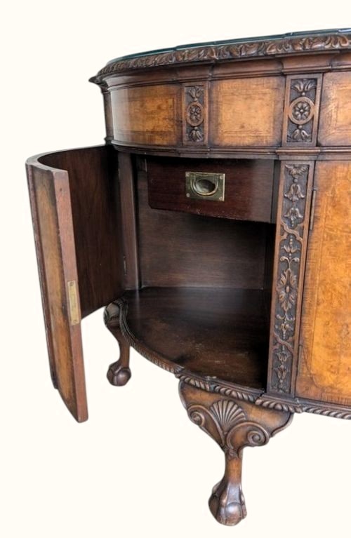 A semicircular burr walnut demi-lune sideboard featuring carved cabriole legs with ball-and-claw feet and decorative foliage carvings on the upright pilasters. View VI