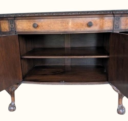 A semicircular burr walnut demi-lune sideboard featuring carved cabriole legs with ball-and-claw feet and decorative foliage carvings on the upright pilasters. View VIII