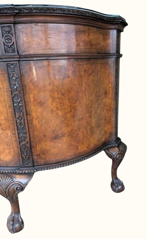 A semicircular burr walnut demi-lune sideboard featuring carved cabriole legs with ball-and-claw feet and decorative foliage carvings on the upright pilasters. View X