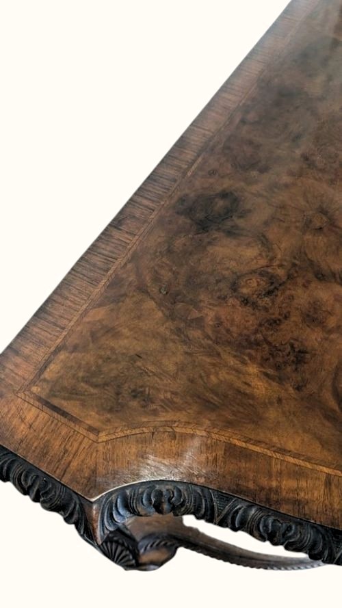 A semicircular burr walnut demi-lune sideboard featuring carved cabriole legs with ball-and-claw feet and decorative foliage carvings on the upright pilasters. View XII