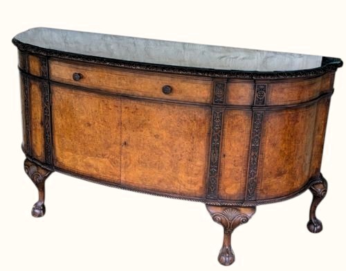 A semicircular burr walnut demi-lune sideboard featuring carved cabriole legs with ball-and-claw feet and decorative foliage carvings on the upright pilasters. View II