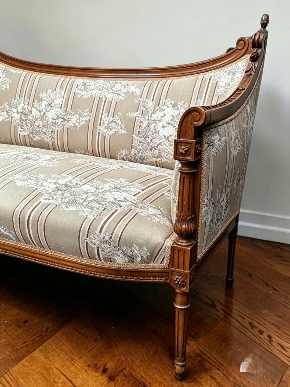 An Edwardian walnut drawing room sofa with a curved backrest, turned finials, slender turned legs, and beige striped floral upholstery. View VI