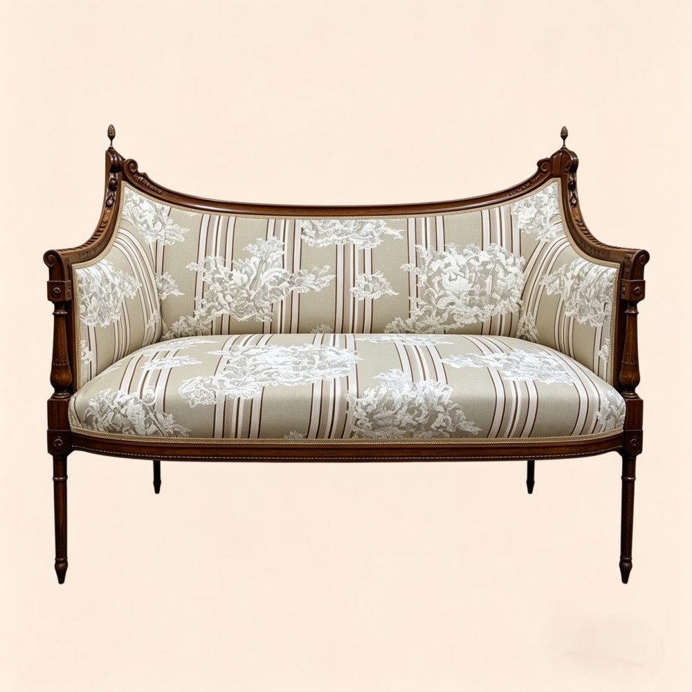 An Edwardian walnut drawing room sofa with a curved backrest, turned finials, slender turned legs, and beige striped floral upholstery.
