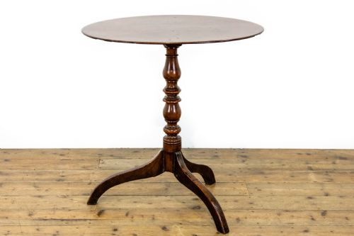 fig 1. An antique mahogany side table featuring an oval top supported by a turned central pedestal and three curved tripod legs.