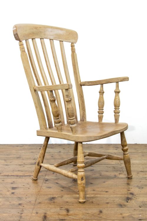 fig 1. A light ash and elm antique Windsor armchair featuring a spindle backrest, turned legs, and a solid shaped wooden seat.