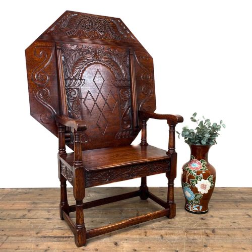 fig 1. An early 20th-century dark oak monks seat featuring an octagonal carved tilt-top backrest, open armrests, turned legs, and stretchers.
