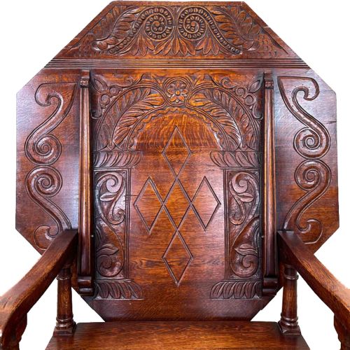 fig 2. An early 20th-century dark oak monks seat featuring an octagonal carved tilt-top backrest, open armrests, turned legs, and stretchers.