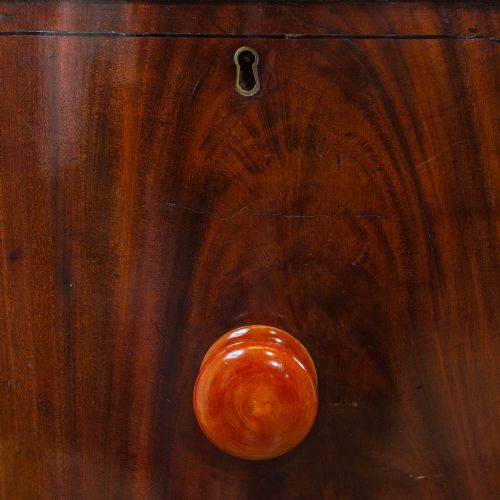 fig 2. An antique mahogany bow-front sideboard featuring turned reeded legs, central drawers, and flanking cupboard doors with turned wooden knobs.