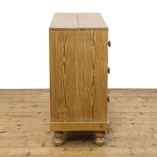 fig 2. A Victorian waxed pine chest of drawers with three full-width drawers, turned wooden handles, and bun feet.