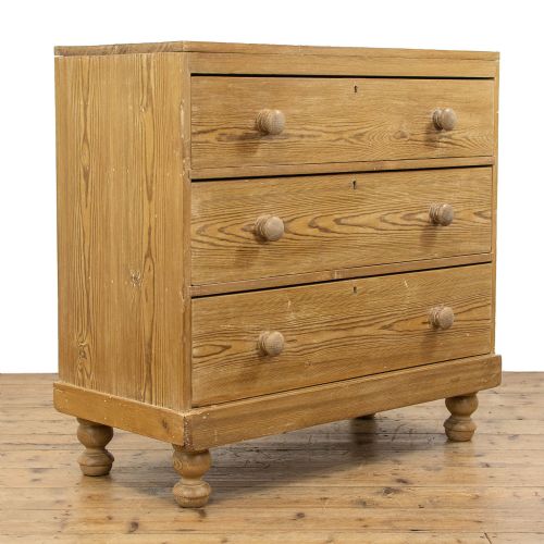 fig 3. A Victorian waxed pine chest of drawers with three full-width drawers, turned wooden handles, and bun feet.