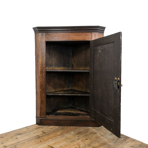 fig 1. An antique Georgian dark oak wall-hanging corner cupboard featuring a moulded top cornice, a single fielded panel door with a central inlaid diamond motif, and a brass keyhole.
