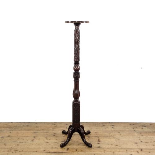 fig 1. A tall dark mahogany torchere stand featuring a circular top, carved acanthus leaf shaft, fluted stem, and a tripod base.