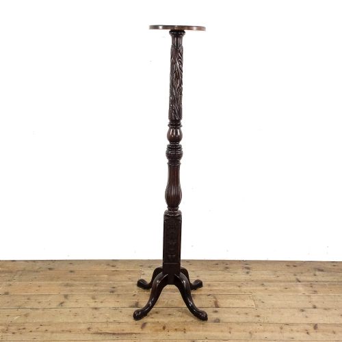 fig 2. A tall dark mahogany torchere stand featuring a circular top, carved acanthus leaf shaft, fluted stem, and a tripod base.